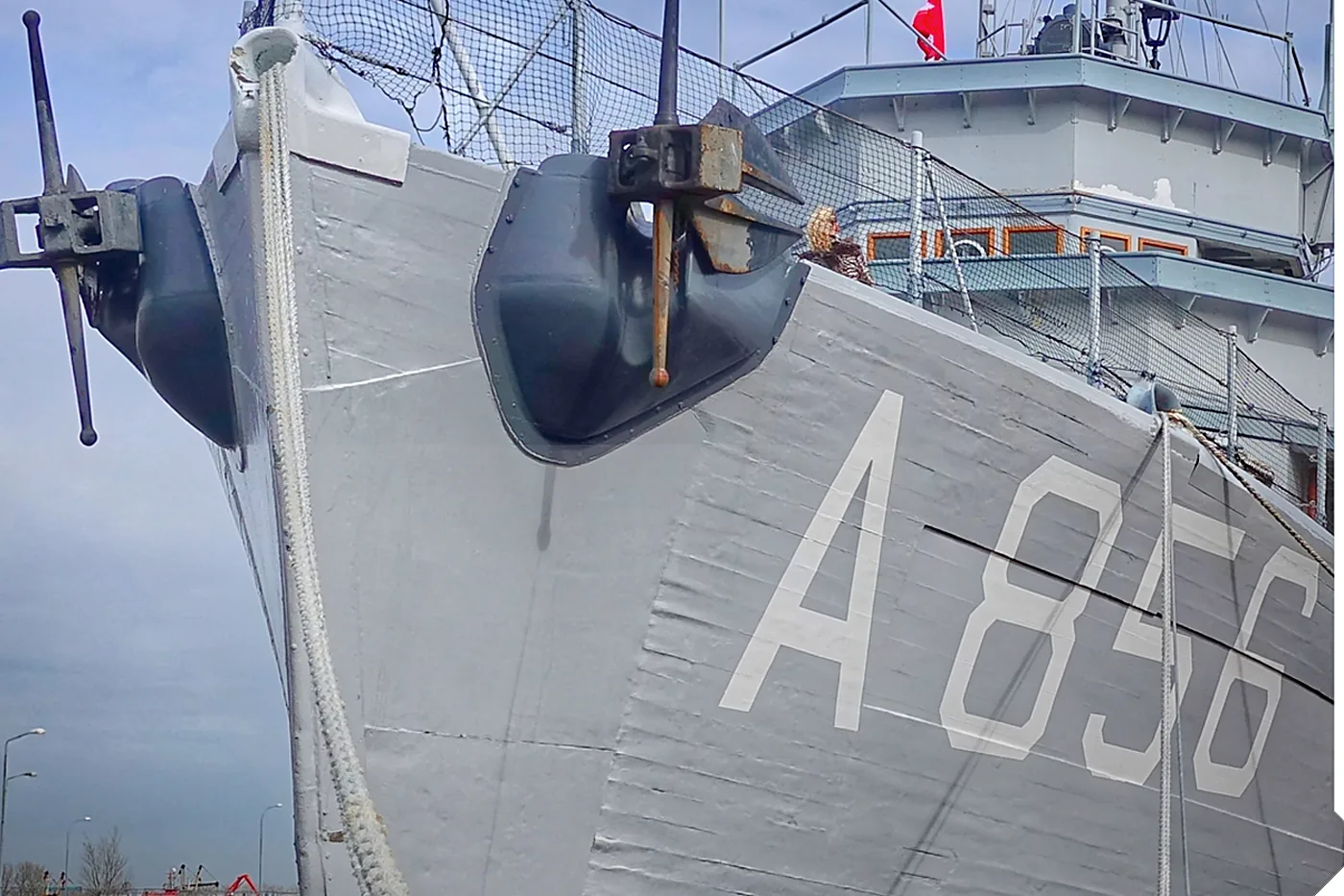 Bow of a vessel alongside with mooring lines made fast