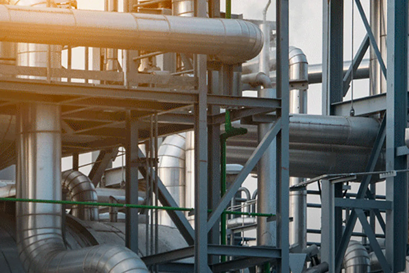 Process plant pipework and pressure vessels at sunrise